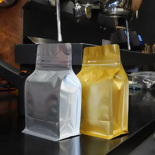 150Bolsas de café G Stock con diseño de fondo plano expuestas en un entorno de cafetería