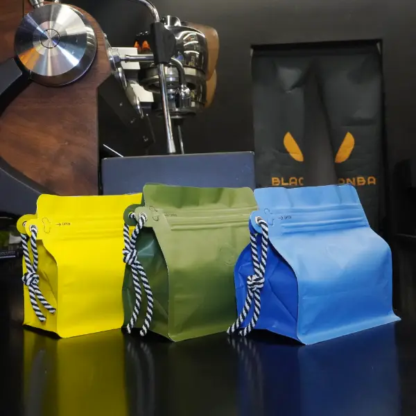 150Bolsas de café G Stock con cordón en color naranja expuesto en la encimera