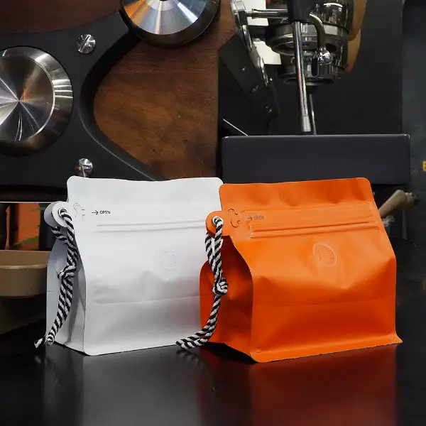 bolsas de café blancas y naranjas de 150g con vista frontal tipo cordón