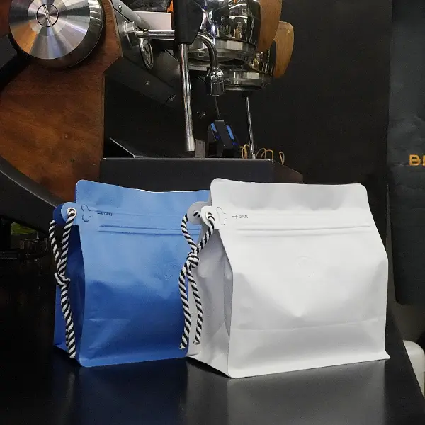 250G bolsas de café con cordón naranja en la encimera de café