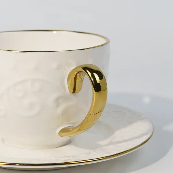 Detalle del mango dorado de una taza cerámica en relieve personalizada
