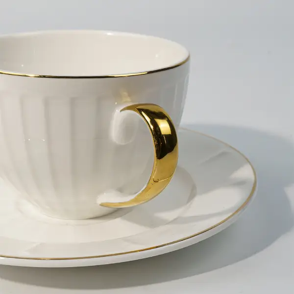 Mango pintado de oro sobre taza de café cerámica en relieve