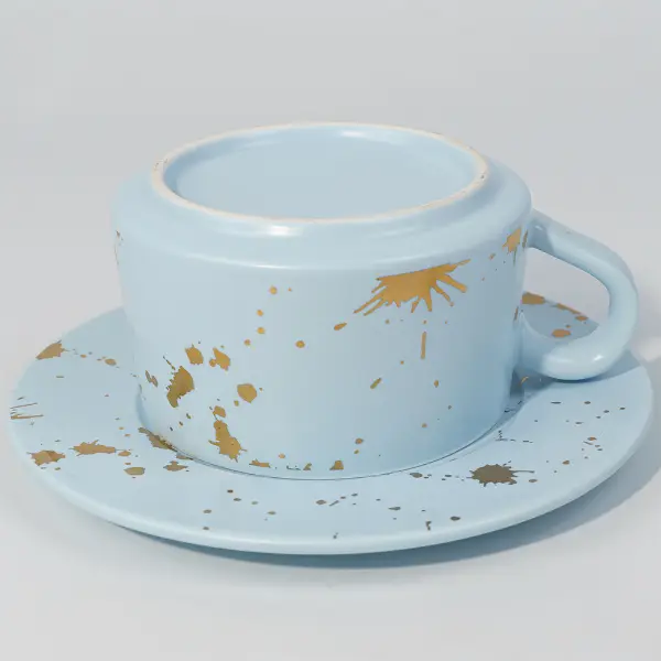 Vista inferior de la taza de café cerámica de pan de oro mostrando un acabado glaseado suave