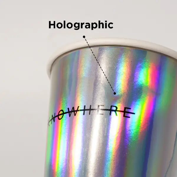 Boca de la taza en primer plano de un vaso de papel holográfico con borde enrollado
