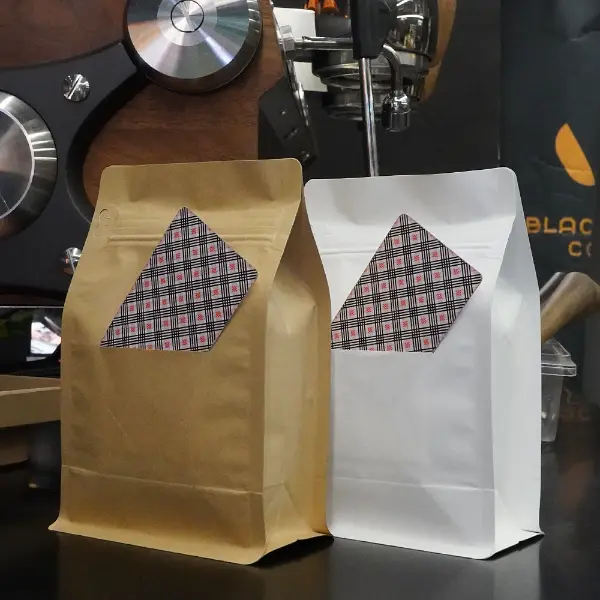 Bolsas de café de papel Kraft con abertura en cartón expuestas en un ambiente de cafetería