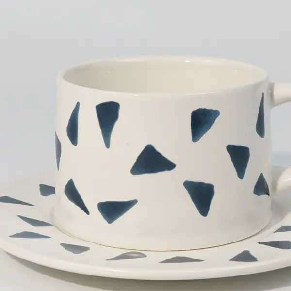 Vista lateral de una taza de café cerámica impresa mostrando el asa y el patrón impreso