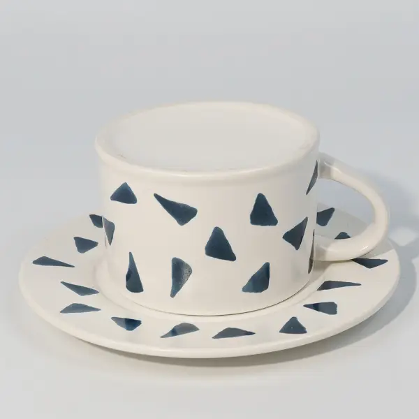 Vista superior de una taza de café de cerámica impresa con platillo para servir café