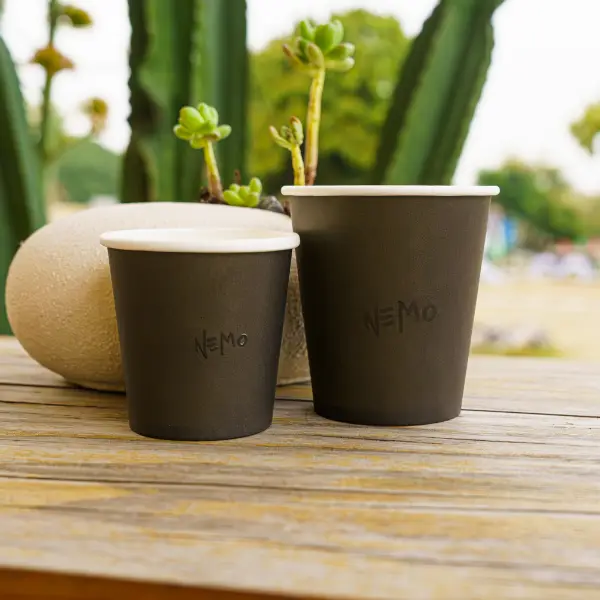 Vasos de papel mate UV personalizados con logotipo en un entorno exterior