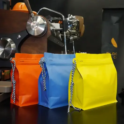 Las bolsas de café personalizadas con cordón ya no son un formato de nicho en 2026. Se han convertido en prácticas, Elección de envases de alto volumen para granos a granel y café molido, especialmente cuando las marcas necesitan tanto fuerza operativa como un producto limpio, Aspecto listo para el comercio minorista. At YPAK, Tratamos el cordón como algo más que una correa. Usado correctamente, se convierte en un punto de manejo funcional y en una señal visual de durabilidad, lo que puede influir en cómo los compradores juzgan la calidad en unos segundos. El embalaje a granel tiene un desafío constante: Debe trabajar duro en la parte trasera, pero aun así representan la marca en el frente. Eso significa estabilidad, Recierre fiable, Gestión del gas, y comodidad de manejo. Cuando esos elementos se juntan, La bolsa deja de ser 
